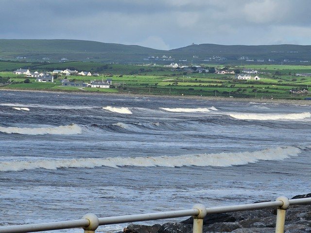 large swell along the beach with the tide on the rocks